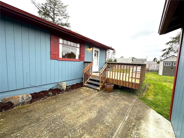 exterior space featuring a front lawn, a shed, an outdoor structure, a deck, and a patio area