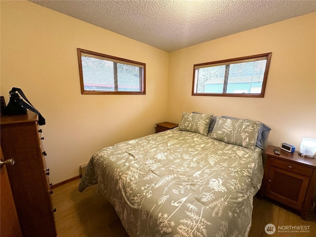 bedroom with a textured ceiling and baseboards