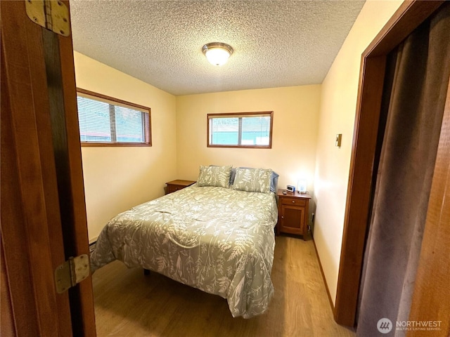 bedroom featuring a textured ceiling and light wood-type flooring