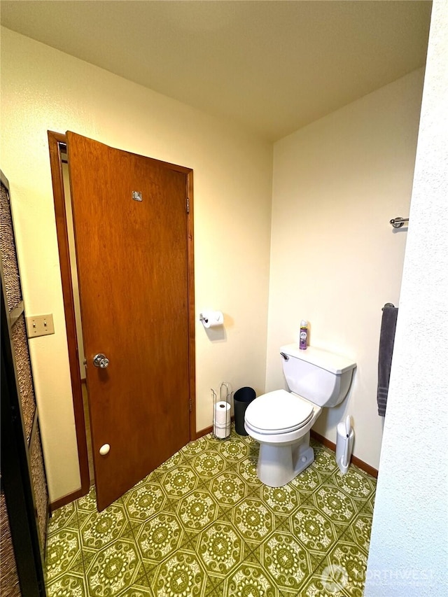 bathroom with baseboards and toilet