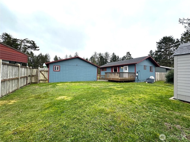 view of yard with a deck, an outdoor structure, and a fenced backyard