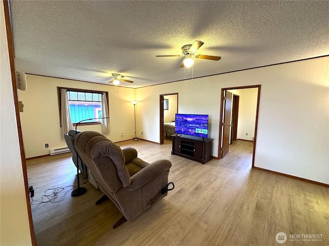 living room with light wood-type flooring, a textured ceiling, a baseboard heating unit, and a ceiling fan