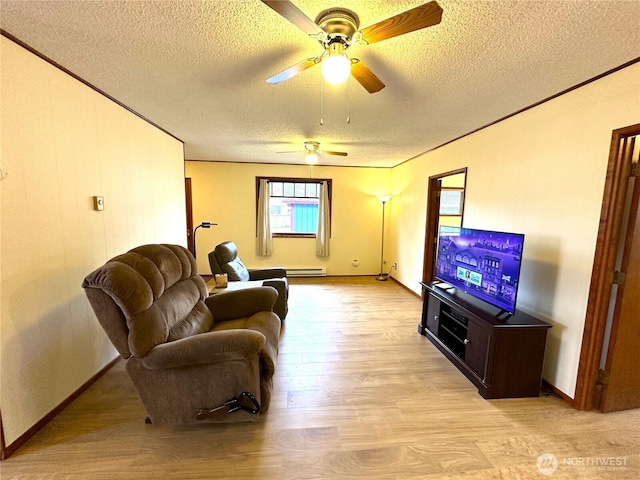 living area with a baseboard heating unit, light wood-style floors, ornamental molding, and a textured ceiling