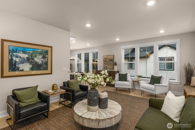 living area with baseboards, wood finished floors, and recessed lighting