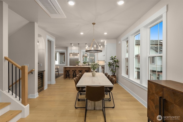 dining area featuring light wood finished floors, visible vents, and a healthy amount of sunlight