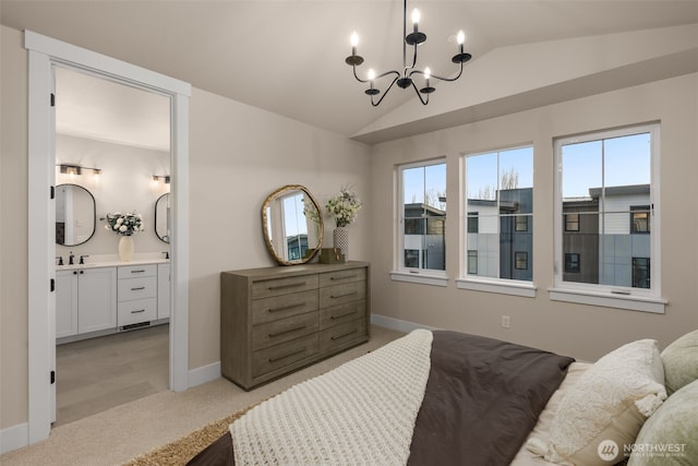 bedroom with connected bathroom, a notable chandelier, light colored carpet, a sink, and vaulted ceiling