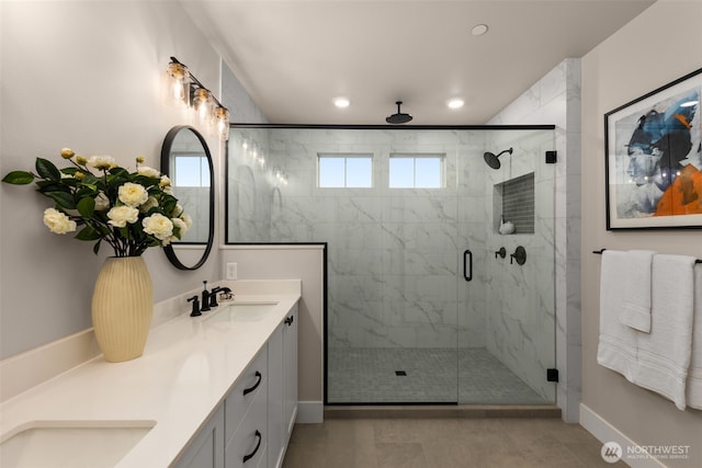 full bathroom with double vanity, a stall shower, a sink, and recessed lighting