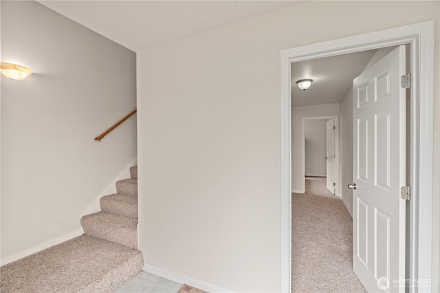 stairs featuring baseboards and carpet flooring