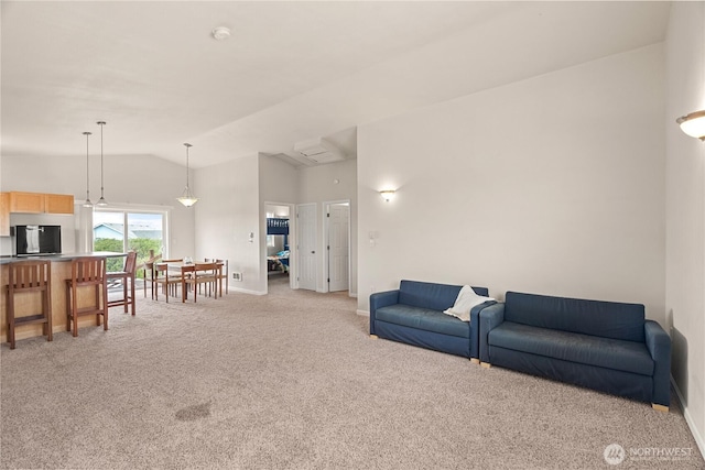 living area with baseboards, light carpet, and high vaulted ceiling