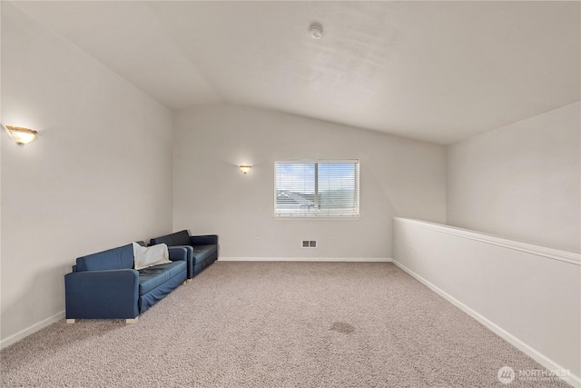 sitting room featuring visible vents, carpet floors, baseboards, and vaulted ceiling