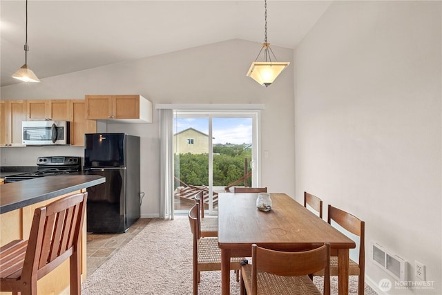 dining area featuring vaulted ceiling, stone finish floor, and visible vents