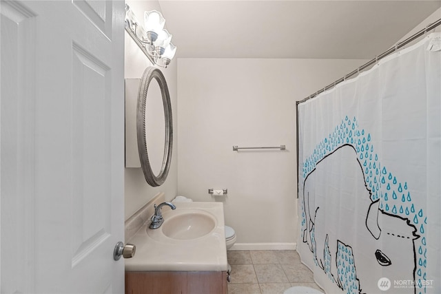 bathroom with tile patterned floors, toilet, vanity, and baseboards