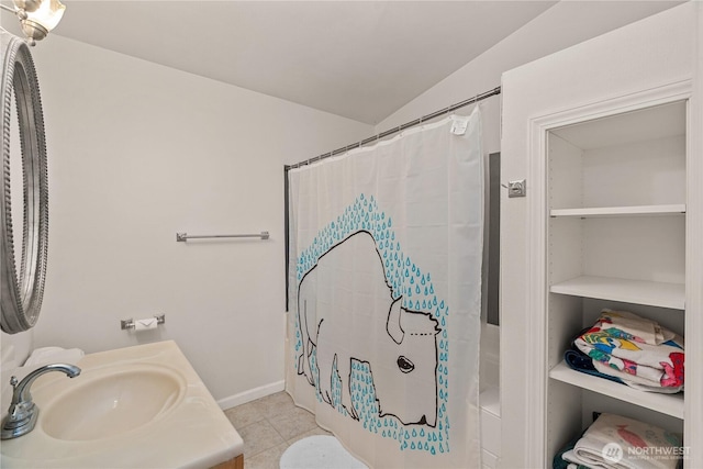 full bath featuring tile patterned flooring, vanity, and lofted ceiling