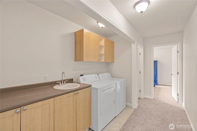 clothes washing area with baseboards, cabinet space, a sink, washing machine and dryer, and light colored carpet