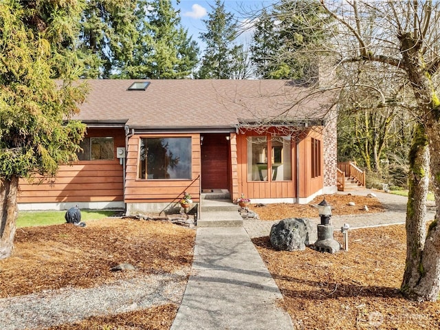 view of front of house with a chimney and a shingled roof