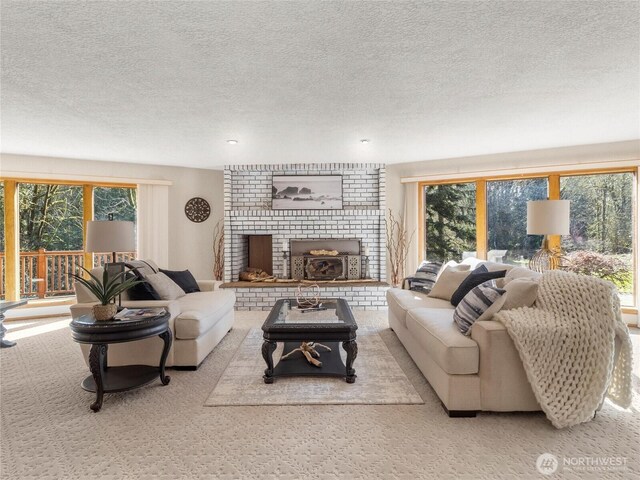 living room with a wealth of natural light, carpet, a fireplace, and a textured ceiling