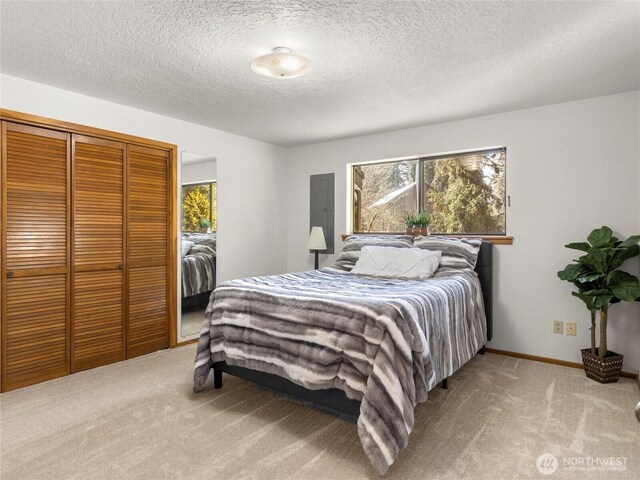 bedroom with a closet, carpet flooring, a textured ceiling, and baseboards