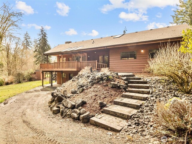 back of house featuring a deck, stairs, and a sunroom