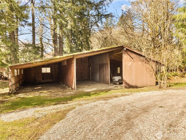 view of pole building with a carport and driveway