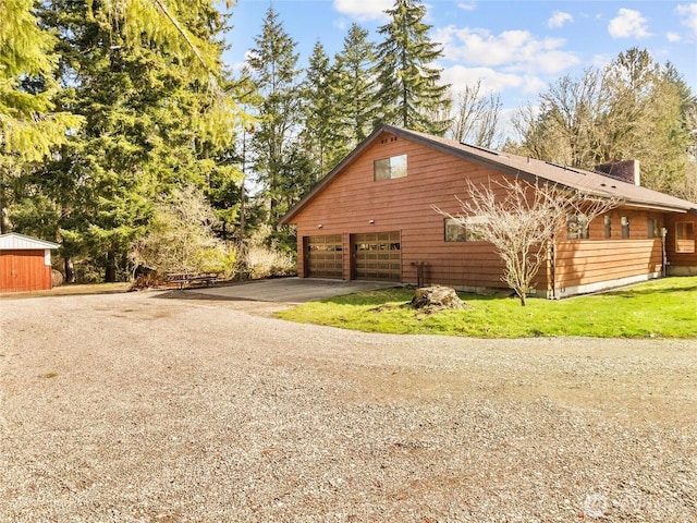 view of side of home featuring aphalt driveway and a garage