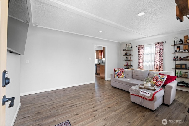 living area featuring a textured ceiling, recessed lighting, wood finished floors, and baseboards