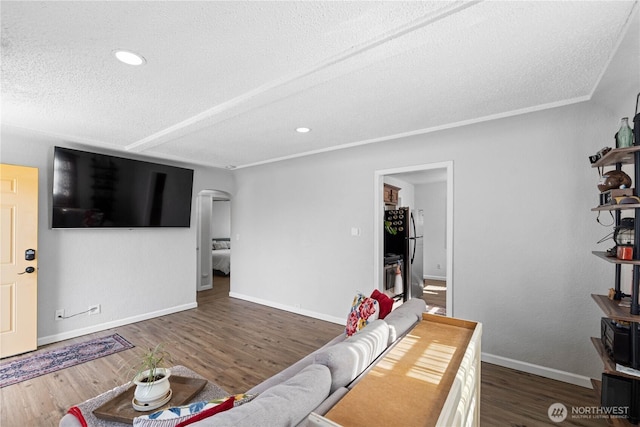 living room with baseboards, arched walkways, wood finished floors, a textured ceiling, and recessed lighting