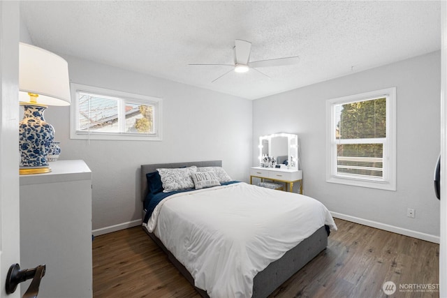 bedroom featuring a ceiling fan, a textured ceiling, baseboards, and wood finished floors