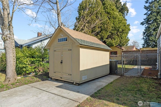 view of shed featuring fence and a gate