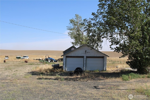 detached garage featuring a rural view