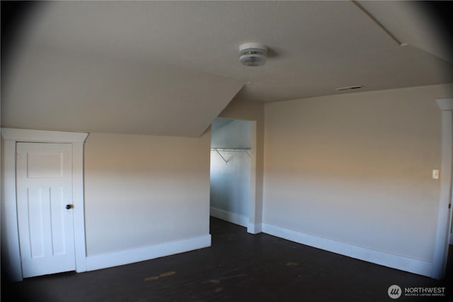 additional living space featuring visible vents, baseboards, and vaulted ceiling