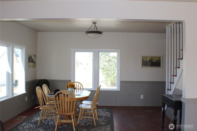 dining room with stairway, wood finished floors, visible vents, and wainscoting