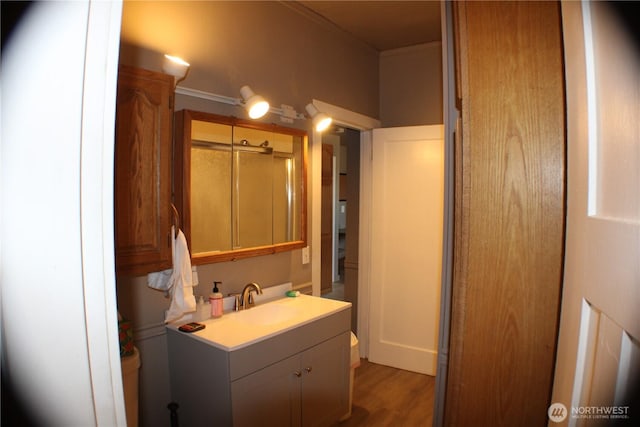 bathroom with a stall shower, vanity, and wood finished floors