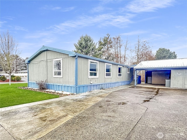 view of property exterior with a yard and concrete driveway