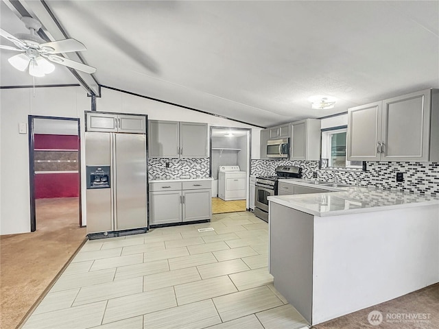 kitchen featuring light countertops, appliances with stainless steel finishes, gray cabinetry, and vaulted ceiling