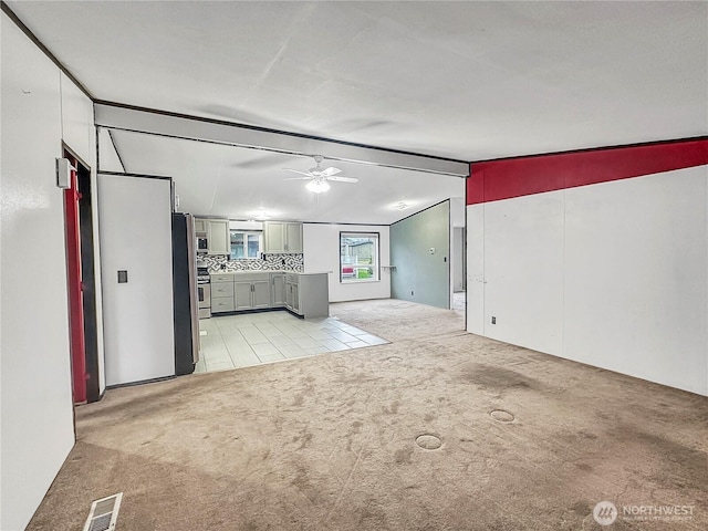 unfurnished living room with light carpet, visible vents, a ceiling fan, and vaulted ceiling