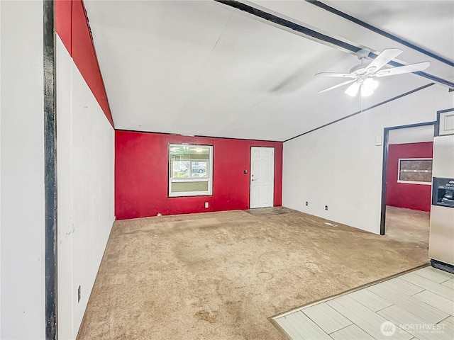 unfurnished living room featuring lofted ceiling with beams, carpet flooring, and a ceiling fan