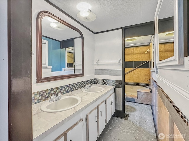 full bathroom with a textured ceiling, double vanity, tasteful backsplash, and a sink