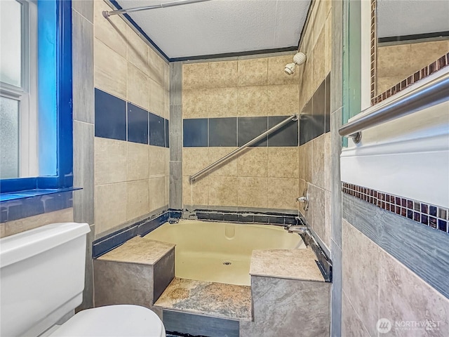 full bathroom featuring toilet, a textured ceiling, and tile walls