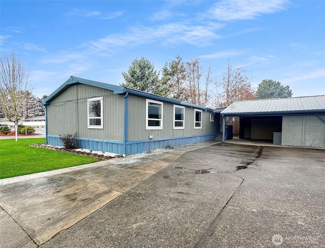 view of front of home with driveway, an attached carport, and a front yard