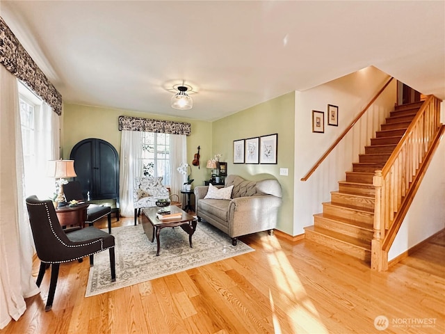 living room with stairs and wood finished floors