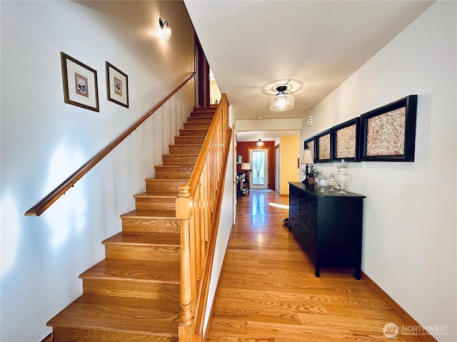 stairway featuring baseboards and wood finished floors