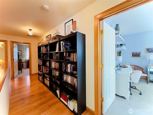 hallway featuring wood finished floors and visible vents
