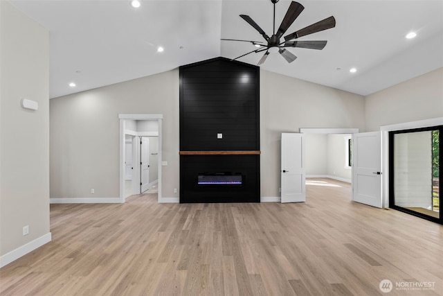 unfurnished living room featuring a ceiling fan, baseboards, light wood finished floors, high vaulted ceiling, and a large fireplace