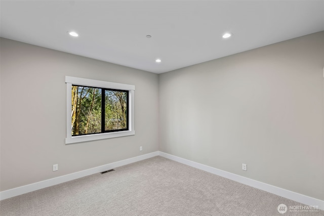 carpeted spare room with recessed lighting, baseboards, and visible vents