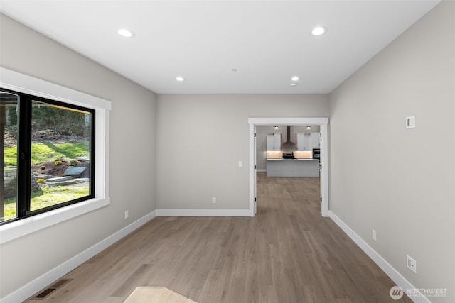 spare room with recessed lighting, visible vents, baseboards, and wood finished floors