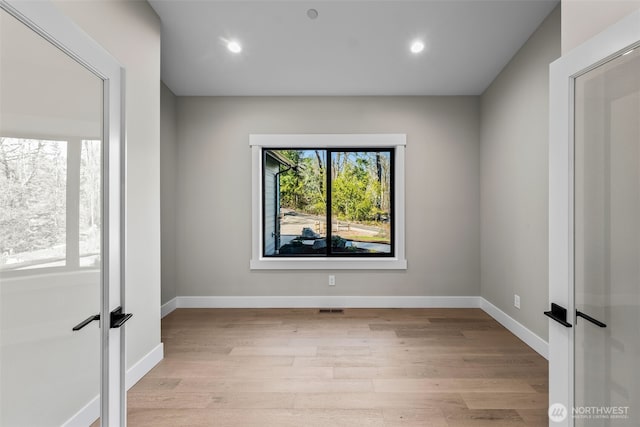 unfurnished room featuring recessed lighting, baseboards, and light wood-style floors