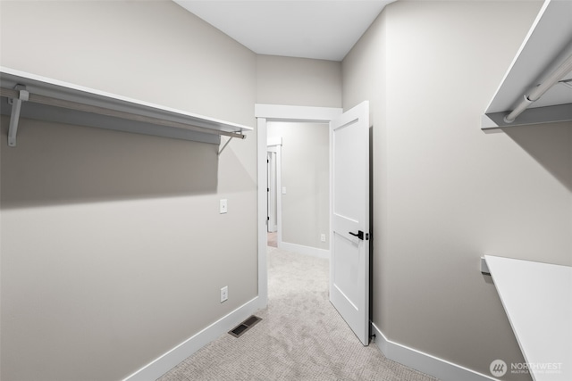 walk in closet with visible vents and light carpet