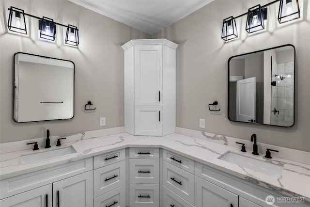 full bath with a sink, double vanity, and a tile shower