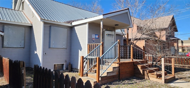 exterior space with metal roof and fence