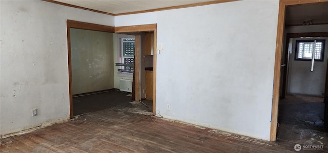 spare room with radiator heating unit and crown molding